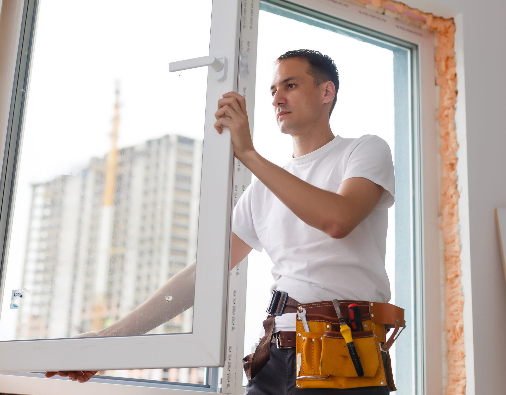 Young handyman repair window with screwdriver